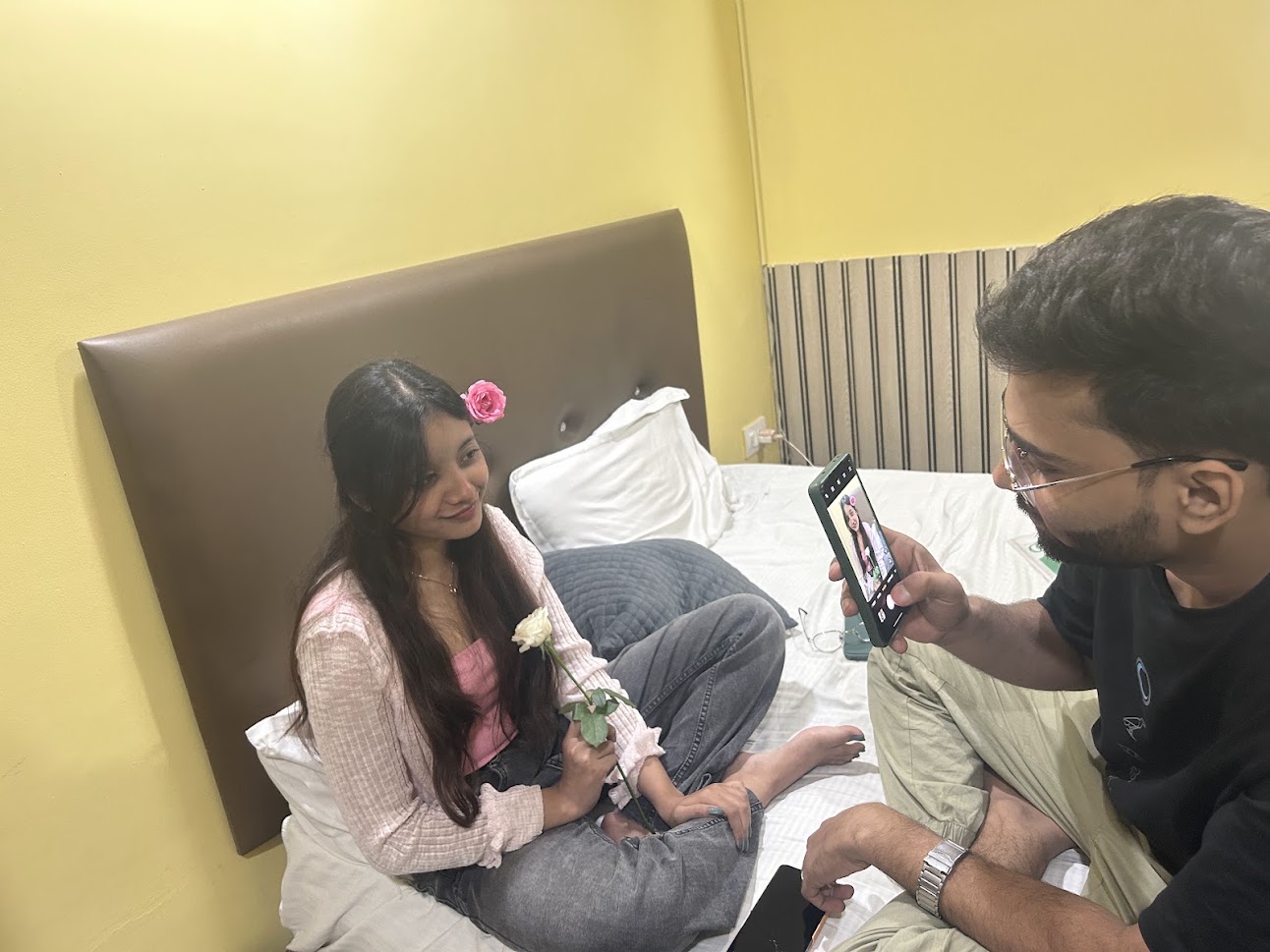 Taking her photograph with roses on a bed